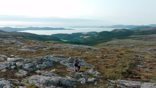 Person With Dog Trekking Over Rugged Terrain Near Rissa And Hasselvika Towards The Mountain Of Blahe