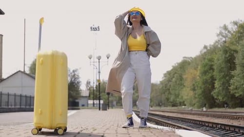 Woman Waits at the Train Station with Luggage