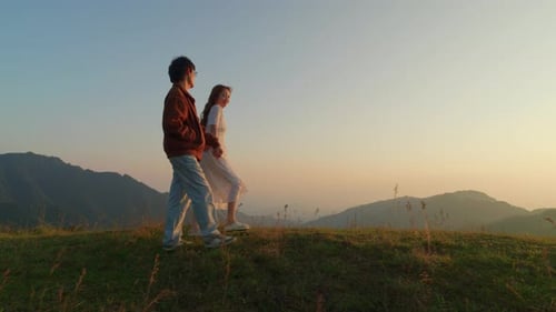 young romantic couple walking together mountain path at sunset in slow motion
