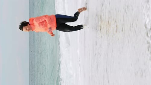 Mulher atlética motivada correndo à beira-mar. Corrida feminina. Vídeo vertical