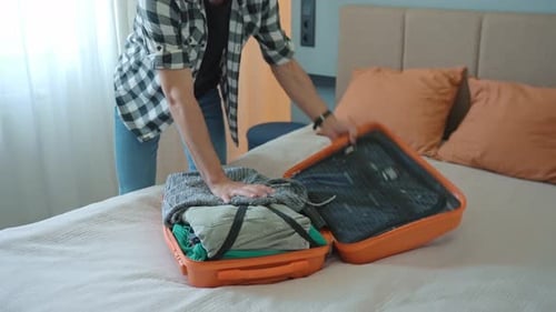 Man Trying to Close Over Packed Suitcase Before Trip