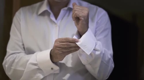 Man Fastening Cufflinks in White Shirt