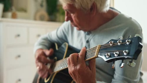 Senior Man Playing Acoustic Guitar at Home