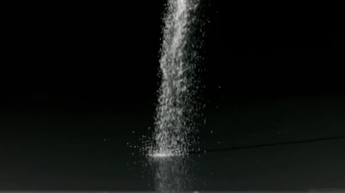 Salt pouring against black background