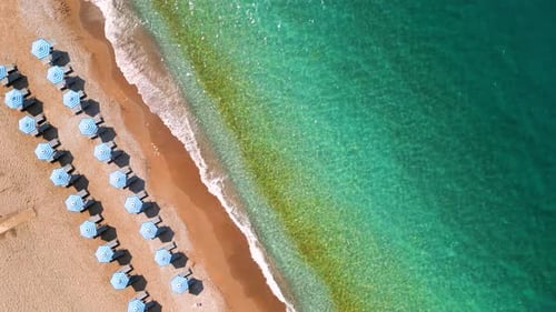 Topdown View of Sandy Beach with Sun Umbrellas and Turquoise Sea Water