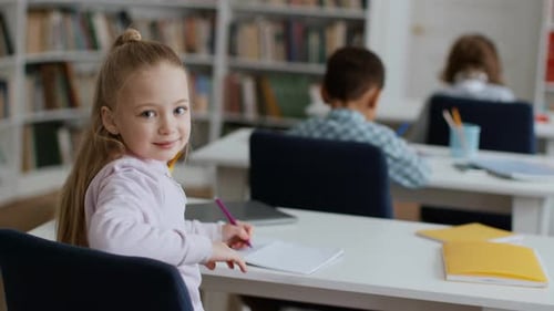Back View Shot of Group of Little Kids Studying at Classroom Cute Schoolgirl Turning to Camera and