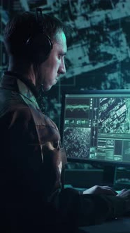 Man Working at Computer in Dark Control Room