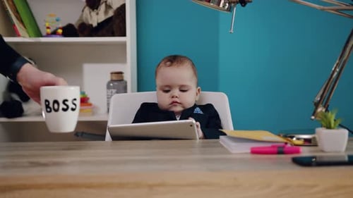 Infant Sits At Desk Using Tablet Indoors