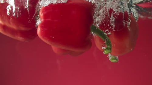 Red Bell Peppers Falling Into Water Tank