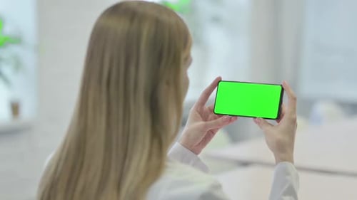 Young Woman Holding Smartphone with Green Screen