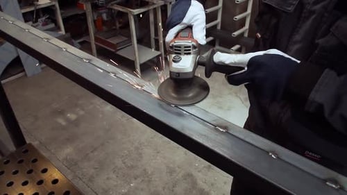 Construction Worker Grinding Metal with Angle Grinder