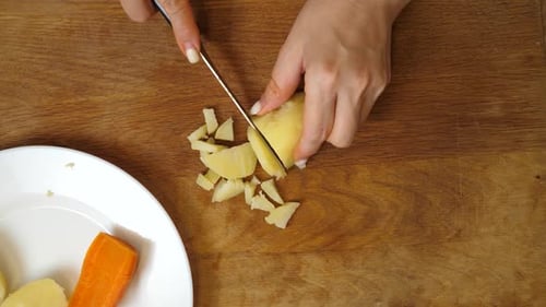 18 1Boiled potatoes and carrots are chopped. A vegetable dish is prepared.