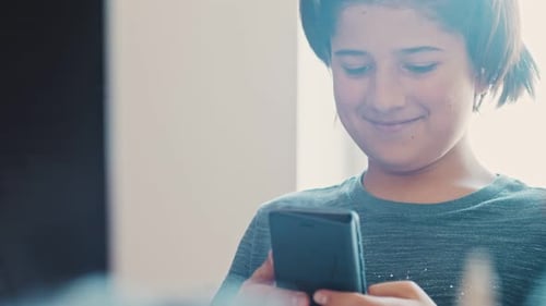 Boy Using Mobile Phone Indoors During The Day