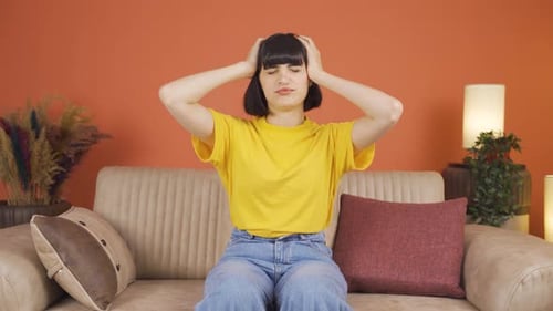 Woman Sitting on Couch with a Headache
