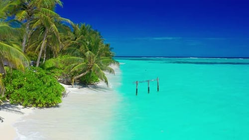 Paradise white sand beach, turquoise ocean, green palm trees and blue sky with clouds on a sunny day