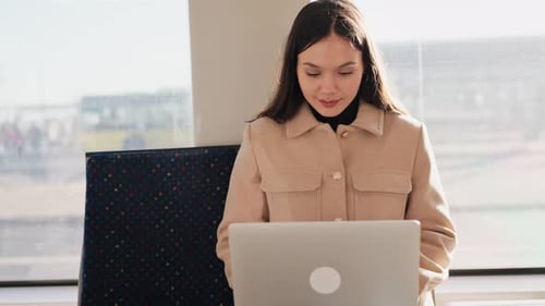 Young Woman Working on Laptop in Moving Tram City Life