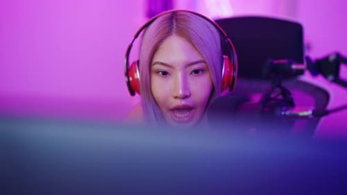 Woman with Headphones Talking into a Microphone