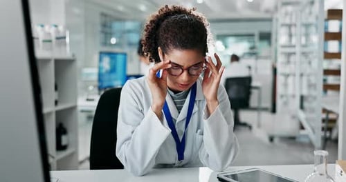 Stressed Scientist Rubbing Temples in Modern Lab