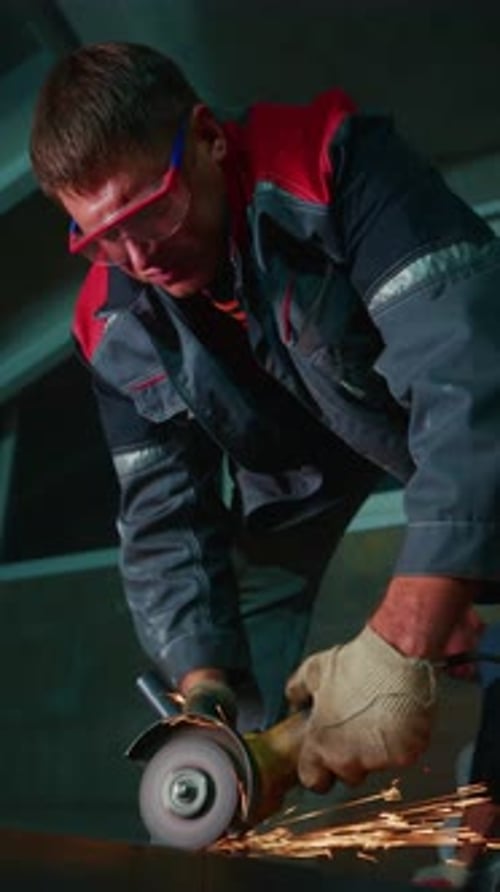 Focused Worker Using Angle Grinder in Workshop Sparks Fly As Metal is Cut Showcasing Dedication and