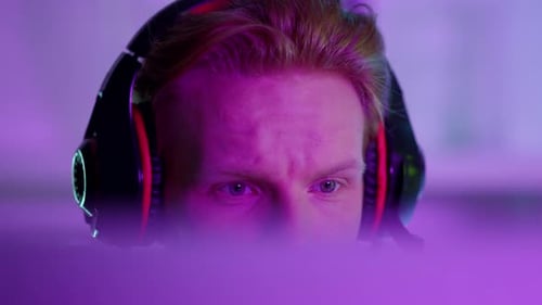 Focused gamer enjoying online tournament in neon cyberspace studio