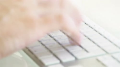 Gros plan des mains d'un homme tapant sur un clavier 4k