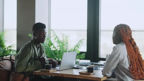 Two People Discuss Business in Modern Office Setting