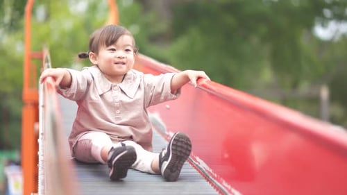 Child on Slide Having Fun in Park
