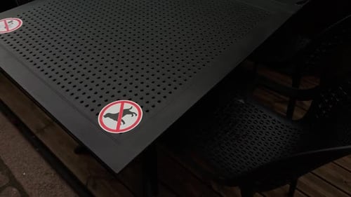 A Table Displaying AntiPest Signage is Prominently Placed in the Outdoor Seating Area for Customer