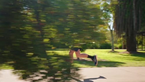 Side Profile Of Man In Sunglasses Jogging On Park Footpath On Sunny Day, 4K Slow Motion