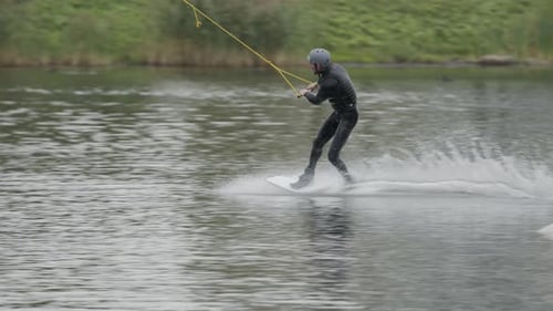 Man Wakeboarding and Jumping Ramp on Lake