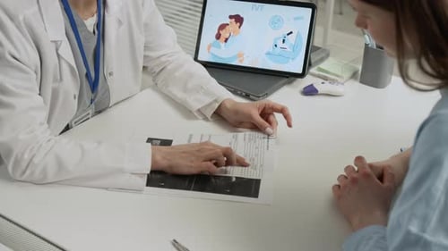 Une fille de la génération Z discute des résultats de l'échographie avec un médecin spécialiste de la fertilité à White Desk