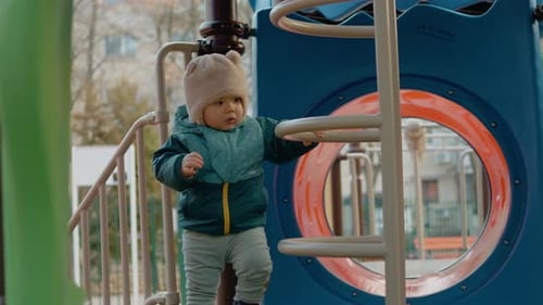 Baby joyfully explores playground slides and takes first steps outdoors