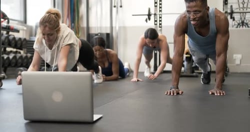 Adults doing plank exercise workout in gym