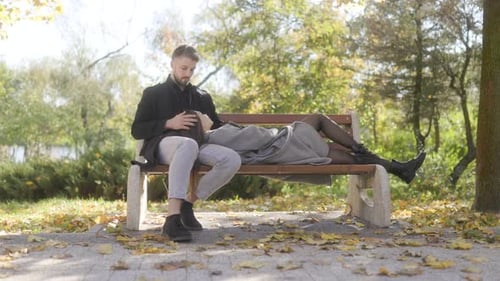 Romantic Scene of a Couple in Love Sitting on a Bench in the Autumn Park