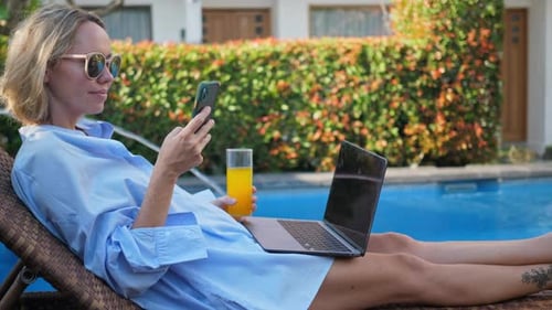 Young Woman Using Laptop Near the Swimming Pool