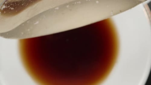 Adding a spoonful of sugar to tea, top view. Dolly slider extreme close-up inside. Laowa Probe