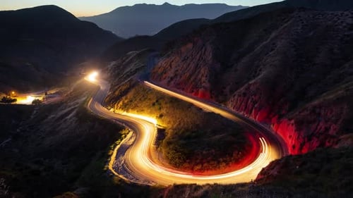 Nachtaufnahme einer Straße, die sich durch die Berge schlängelt