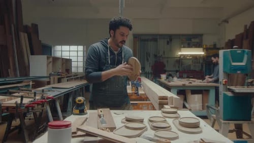 Woodworker Smoothing Wood Plate in Workshop