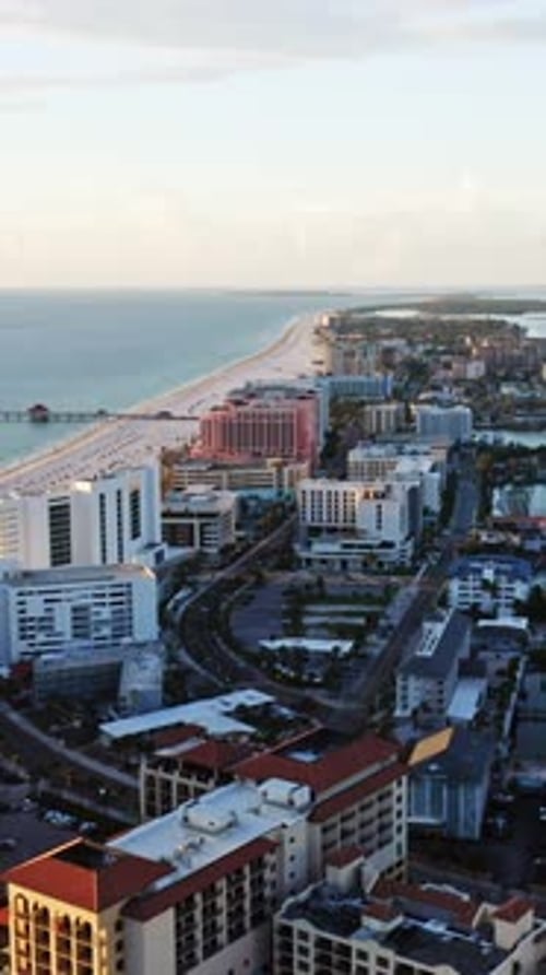 Aerial view of coastal city with beachfront resorts and ocean pier