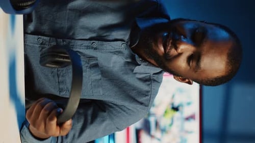 Adult Puts On Headphones Indoors at Desk