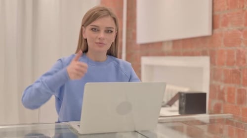 Woman Working at Laptop Gives Thumbs Up