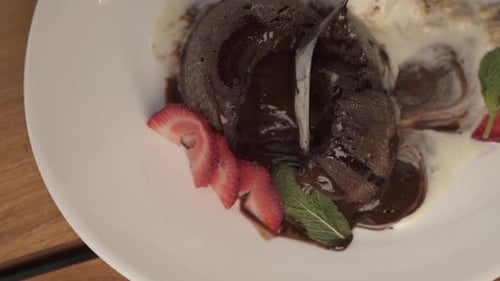 Close up of spoon in chocolate volcano lava dessert. Slow-motion