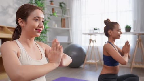 Two Women Doing Yoga in Brightly Lit Room