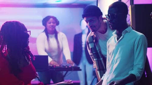 Young Adults Dancing at a Party with Colorful Lights