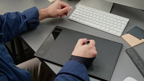Hands of UX Designer zeichnet Produktkonzept mit Grafiktablett und Stift