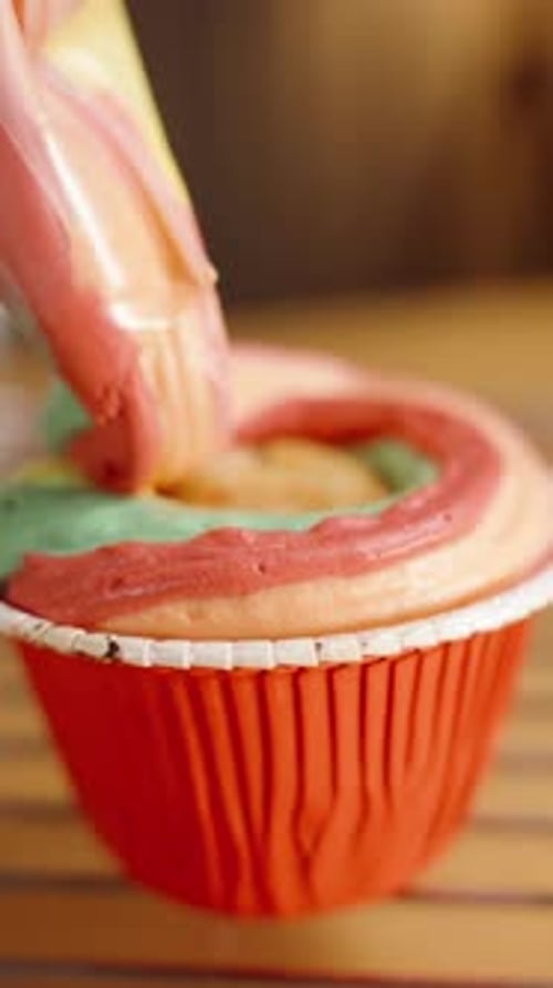Cupcake being decorated with colorful icing