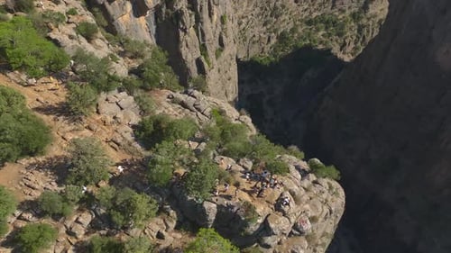 Aerial View Two Friends Pose at the Edge of a Scenic Canyon in Turkey