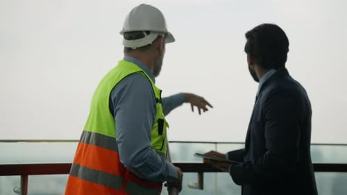 des ouvriers du bâtiment se serrant la main des hommes d'affaires sur un chantier de construction,