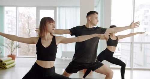 Adults Doing Yoga Poses in Bright Studio
