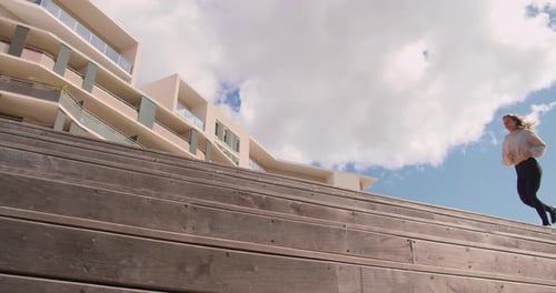 Woman Running Up Stairs in Urban Setting